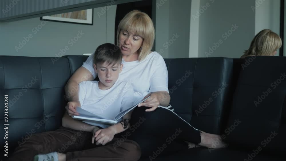 Mom helps my son do homework in the living room. The concept of a happy family Mom helps my son do homework in the living room. The concept of a happy family