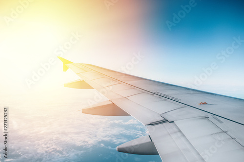 Airplane wing with sunrise in light flare