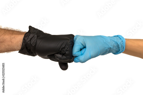 Man and a woman in multi-colored rubber gloves shake hands with each other. Isolate on a faded background. The concept of a successful team of medical interns
