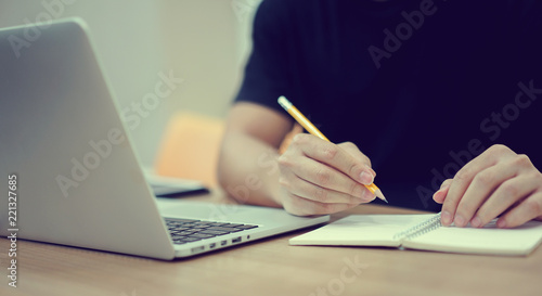 close up student man hand using pencil for doing text exam after finish course online learning , self study education concept	
