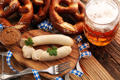 Bavarian veal sausage breakfast with sausages, soft pretzel and mild mustard on wooden board from Germany