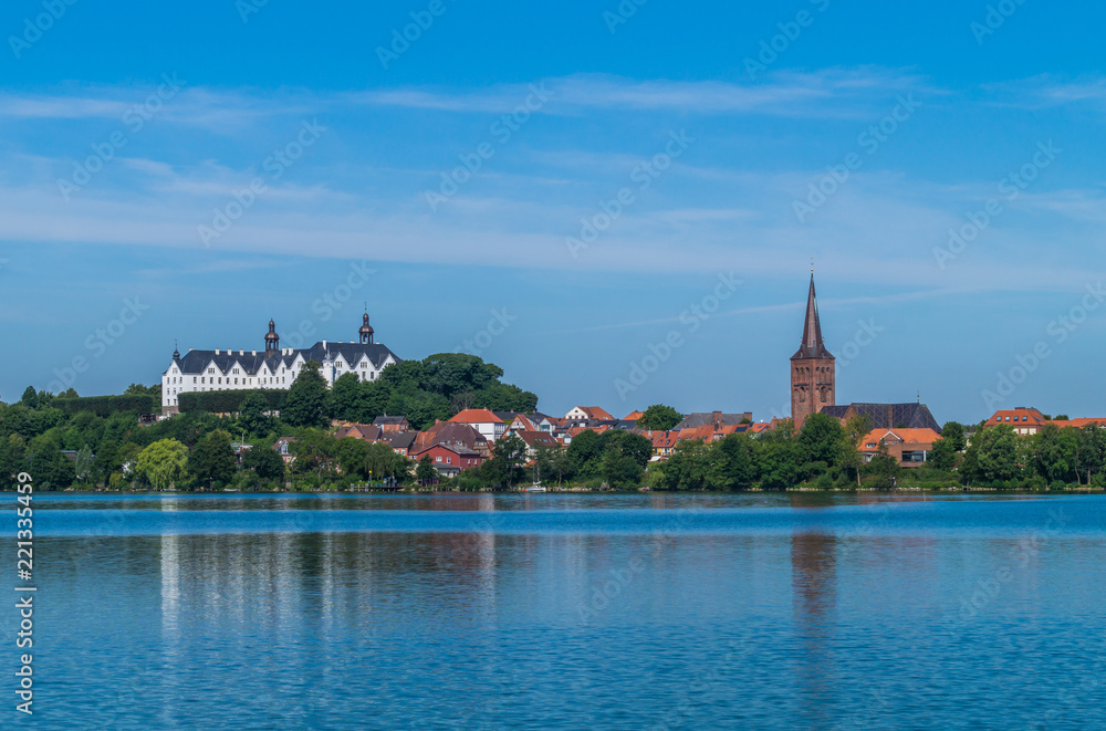 Panorama Blick auf die Stadt Plön vom Plöner See. Wunderschöne Aussicht auf das Plöner Schloss und den Kirchturm von Plön.