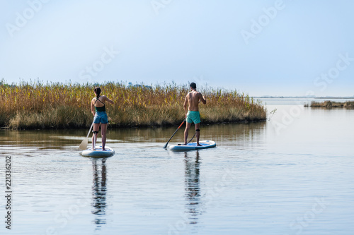 Man and woman stand up paddleboarding