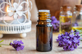 A bottle of lavender essential oil with fresh blooming lavender