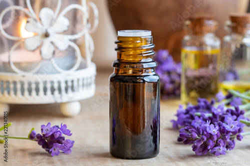 A bottle of lavender essential oil with fresh blooming lavender