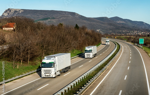 Fleet or convoy of trucks in line on a country highway