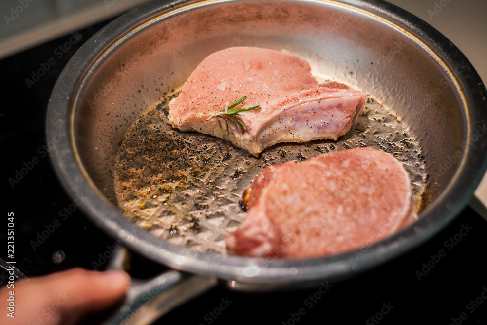 Marinated pieces of pork loin on a bone fry in a frying pan