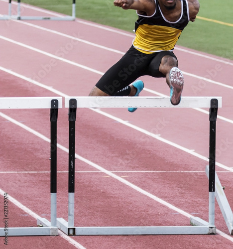 African American running the hurdles race on a track