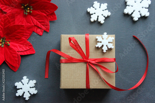 Christmas composition. Gift box with red satin ribbon, wood and snowflakes on black background.  Toys Christmas decor. Extensive series of holiday pictures with various props and backgrounds. A lot of