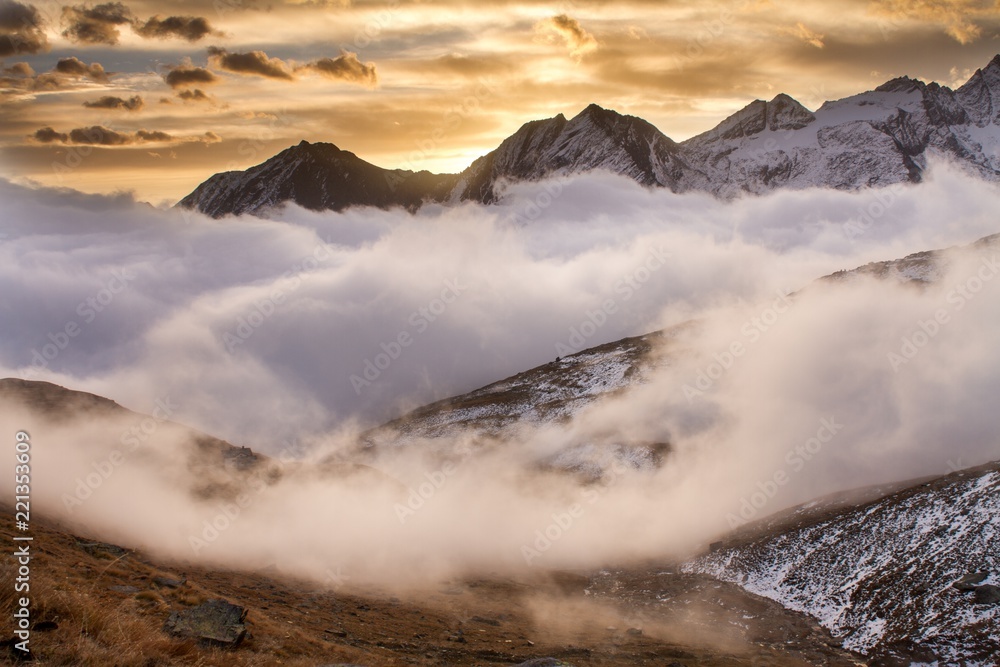 Fototapeta premium Great view of the foggy valley in Gran Paradiso National Park, Alps, Italy, dramatic scene, beautiful world. colourful autumn morning,scenic view with cloudy sky, majestic dawn in mountain landscape