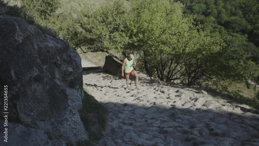 A man climbs the ancient stone pavement in the cave town. Crimea, Chufut Kale.