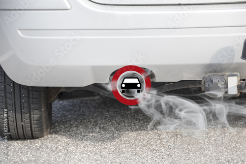 Exhaust from a car with the traffic sign for driving ban, in german Fahrverbot for diesel motor vehicles in the low emission zone of some cities of Germany photo