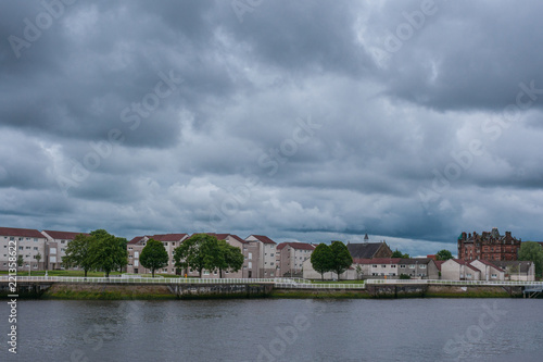 Glasgow, Scotland, UK - June 17, 2012: Napier neighborhood across River Clyde from Riverside Museum under heave rain cloudscape. Beige condominium complexes with red saddle roofs.