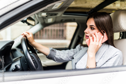 Young business Woman using her phone while driving the car