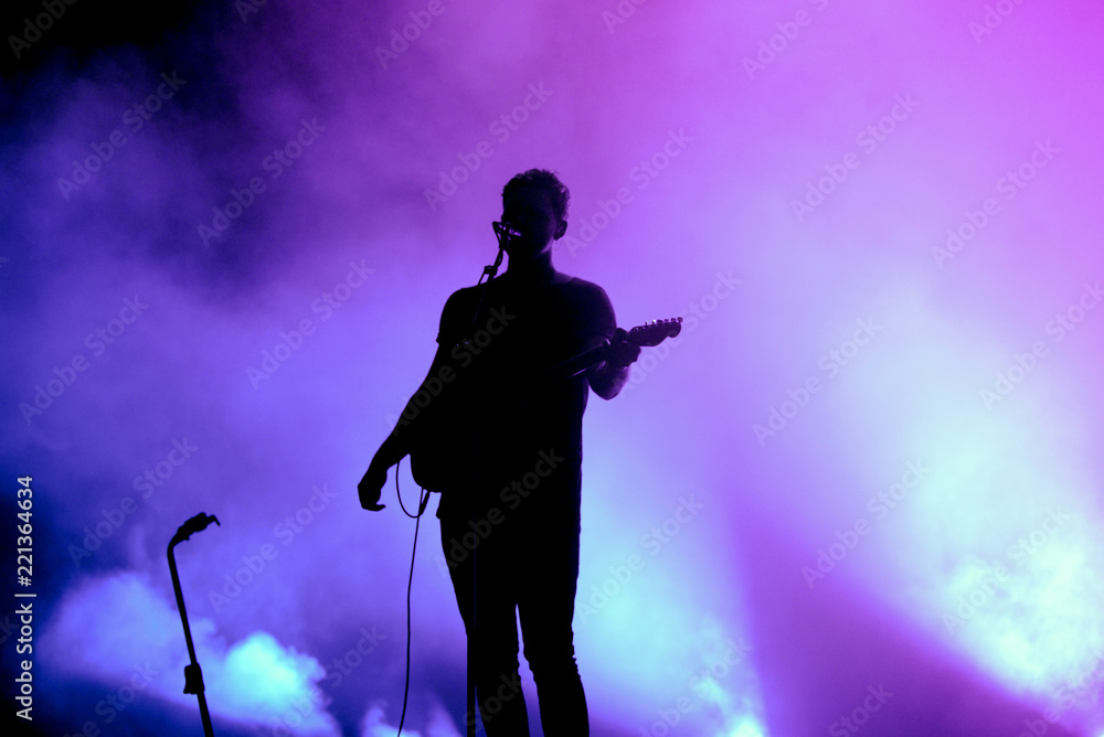 Silhouette of an unregnizable guitarist and singer