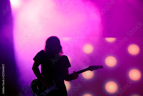 Silhouette of an unregnizable guitarist in a pink background
