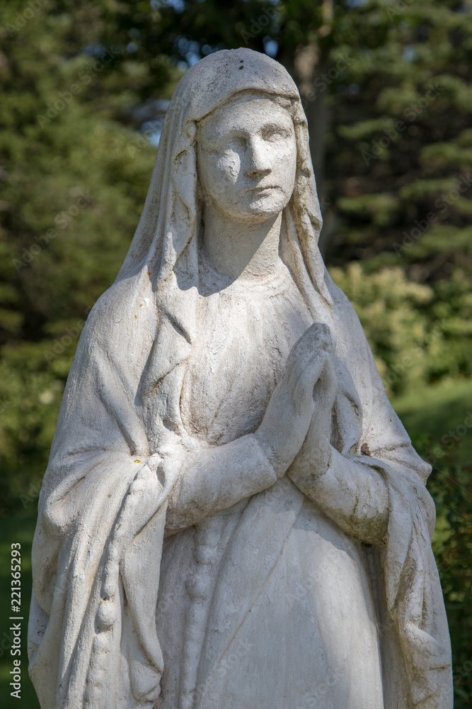 Closeup bust of woman praying statue in garden. Closeup bust of woman praying statue in garden.