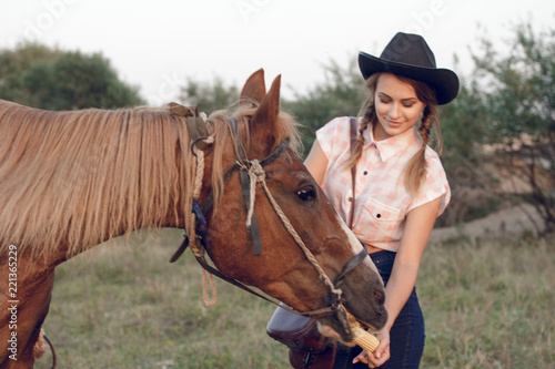 girl in cowboy black hat shirt jeans with horse