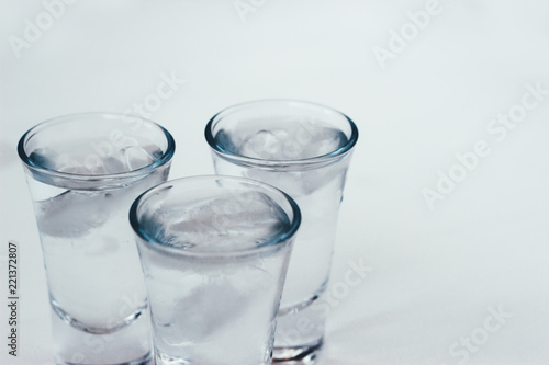 Vodka shots with ice on a white background
