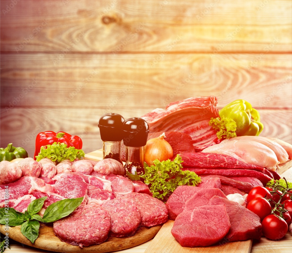 Fresh raw meat with vegetables on brown wooden table at wooden Fresh raw meat with vegetables on brown wooden table at wooden