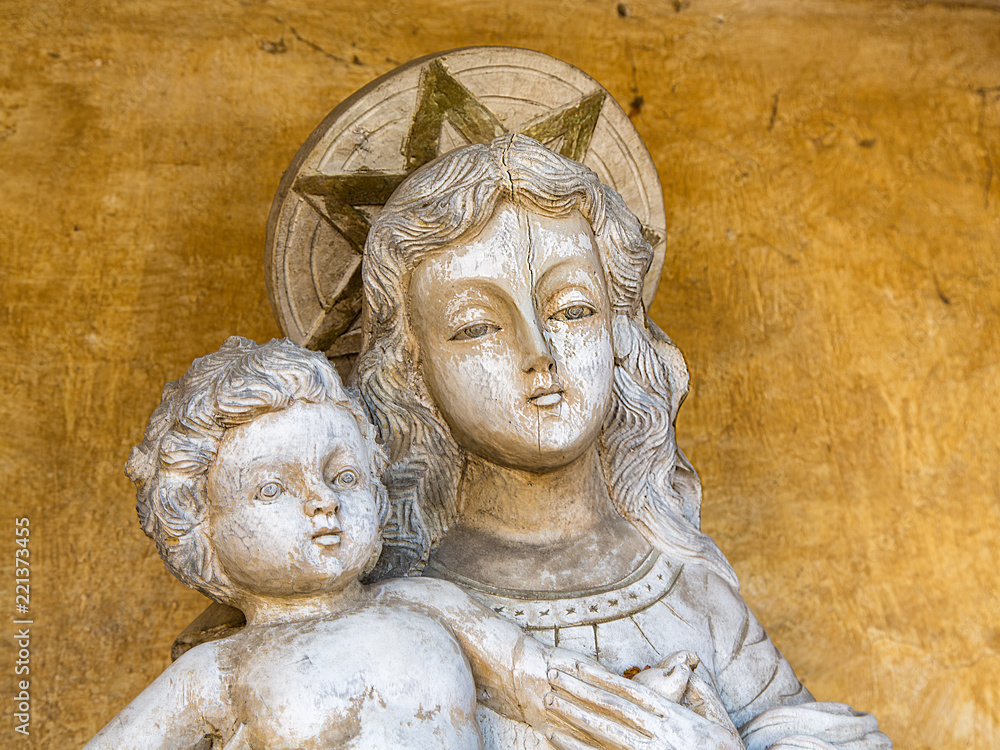 Madonna and Child Statue Against a Yellow Plaster Wall