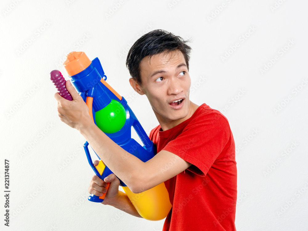 Young man with water gun toy Thailand Songkran Festival. Asian one person wear red short sleeves. isolated. Young man with water gun toy Thailand Songkran Festival. Asian one person wear red short sleeves. isolated.