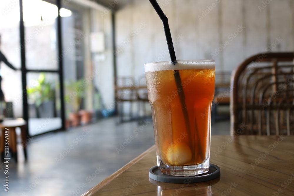 Sweet cold tea drinks are served on a wooden table inside the cafe Sweet cold tea drinks are served on a wooden table inside the cafe