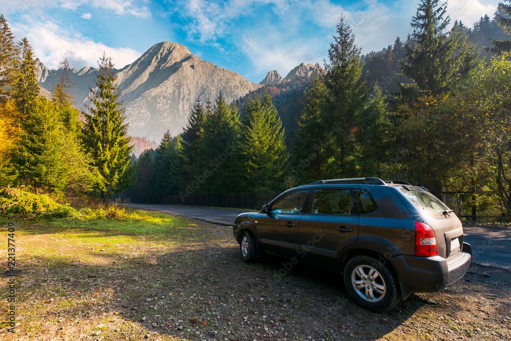 SUV on countryside road in High Tatra mountains. lovely transportation scenery at sunrise in autumn. disover Slovakia travel by car concept. composite image