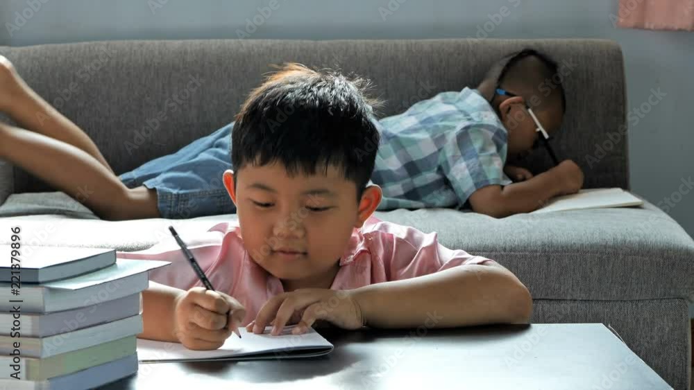 Cute little boy asian thinking and write into book, Happy smile at home. education concept Cute little boy asian thinking and write into book, Happy smile at home. education concept