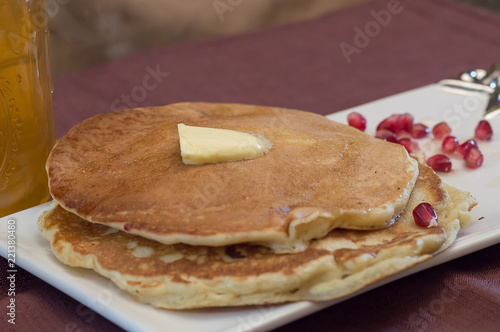 Stack of pancakes with maple syrup and butter topping