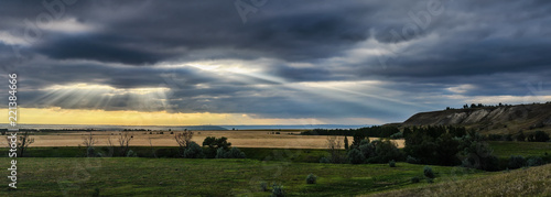 Landscape with big wheat field. weather change. Sun rays. photo