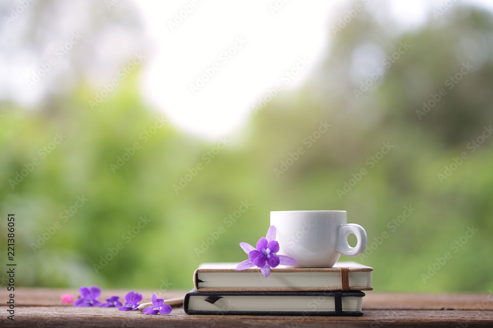 White cup and notebook with flower at outdoor White cup and notebook with flower at outdoor