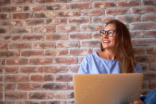 Portrait of happy successful Caucasian businesswoman in blue shirt and glasses. Home office concept