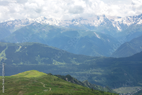 panorama of gorge with green grass and big mountain with snow
