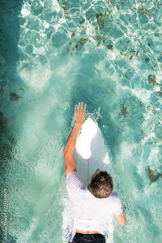 Canvas Print a young guy is practicing surfing in a swimming pool