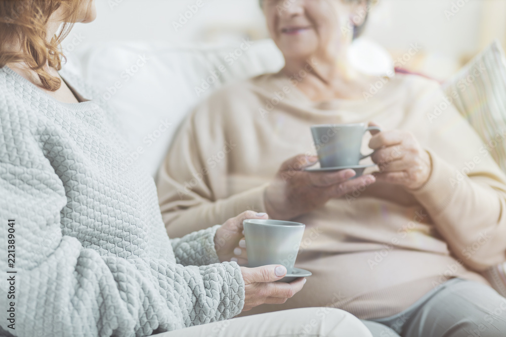 Senior women drinking tea during conversation in a nursing house Senior women drinking tea during conversation in a nursing house