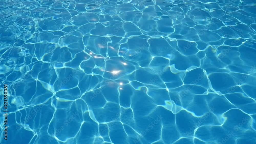 An idyllic view of swaying cyan-blue waters in a swimming pool with dazzling diamond forms making an inspiring background shot askew An idyllic view of swaying cyan-blue waters in a swimming pool with dazzling diamond forms making an inspiring background shot askew