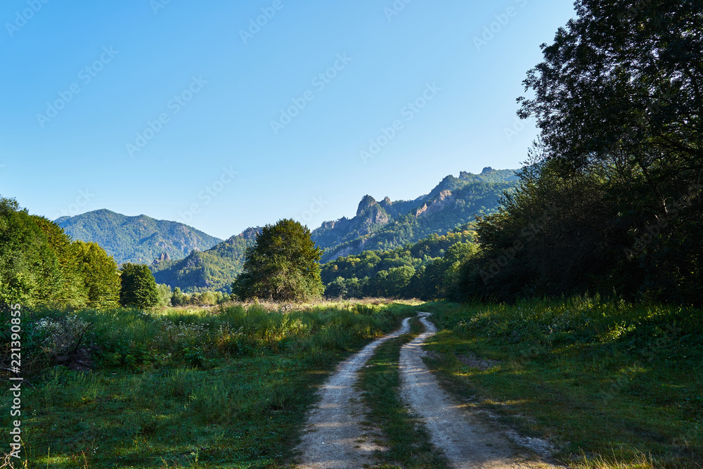Fototapeta premium Picture of a dirt road in the mountains.