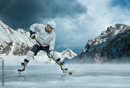 Photography Ice hockey player in action outdoor around mountains