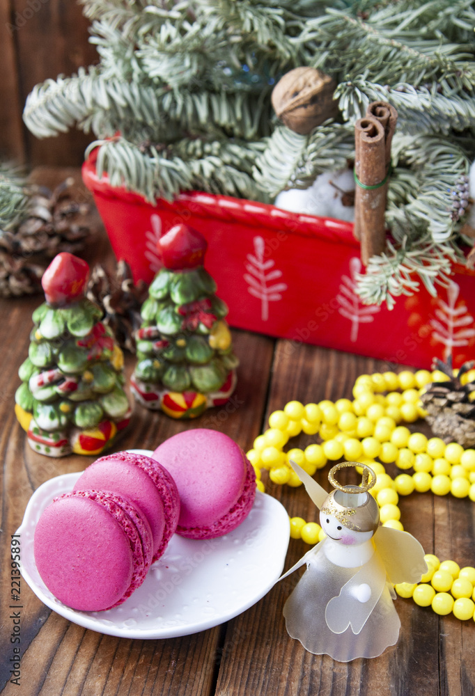 Pink macaroons with christmas decorations on woooden background