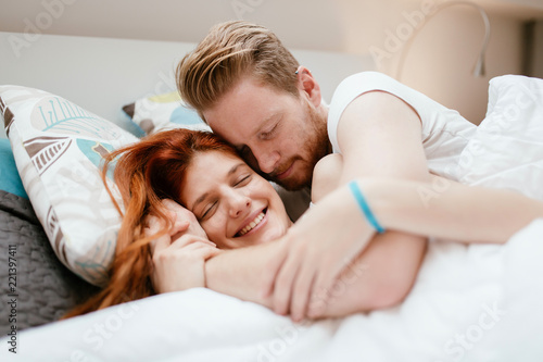 Beautiful couple smiling in bed