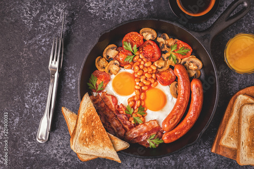 Traditional full English breakfast with fried eggs, sausages, beans, mushrooms, grilled tomatoes and bacon.