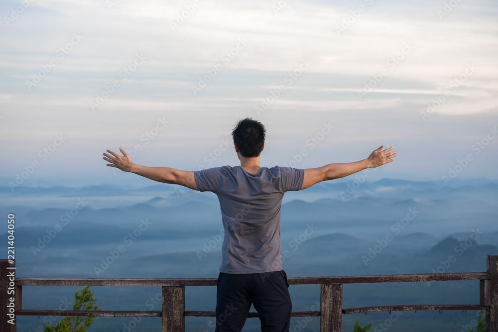 Handsome man standing with extend arms action over the landscape ...