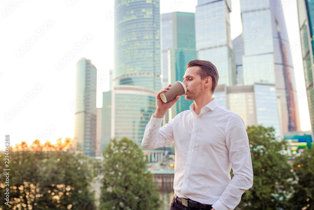 Businessman looking on copy space while standing against glass skyscraper Businessman looking on copy space while standing against glass skyscraper