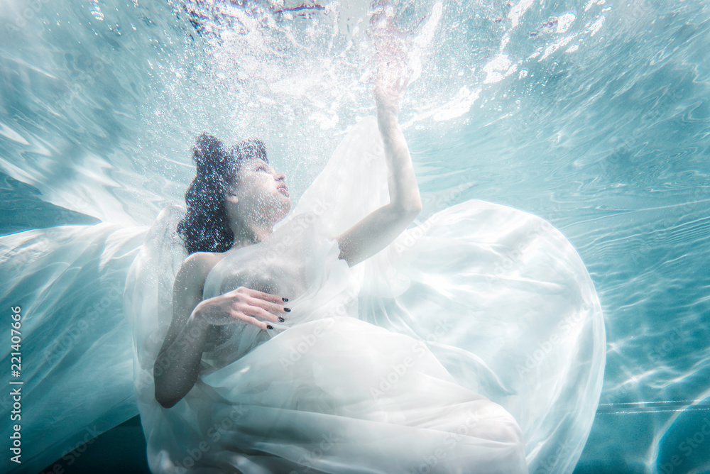 Beautiful woman swimming with fancy dress underwater Stock Photo ...