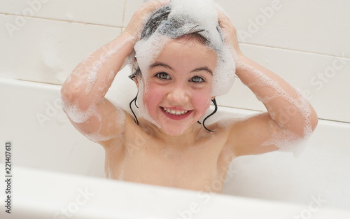 Pretty little girl taking a foam bath
