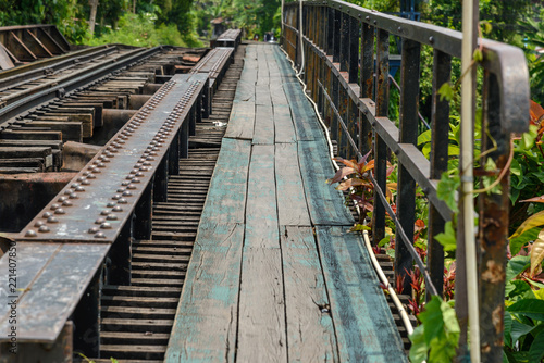 wooden sidewalk side of railway bridge over the canal in Thailand