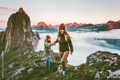 Happy Couple holding hands traveling together hiking in Norway healthy lifestyle concept active vacations outdoor Segla mountain sunset landscape