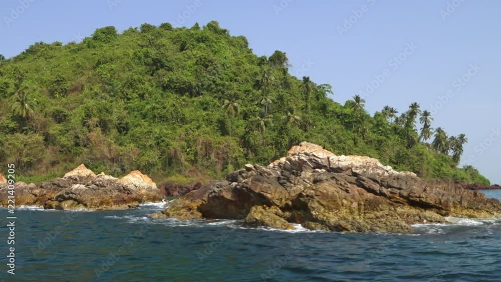 The boat circles a bright green island in this wide shot from a boat The boat circles a bright green island in this wide shot from a boat