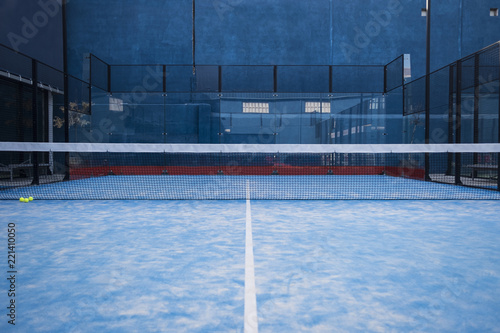 Paddle tennis court, net, racket, balls. photo
